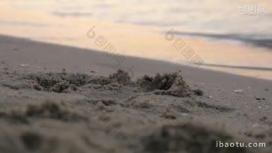 近距离拍摄的沙滩上的<strong>沙子</strong>和海浪翻滚在海岸在日落